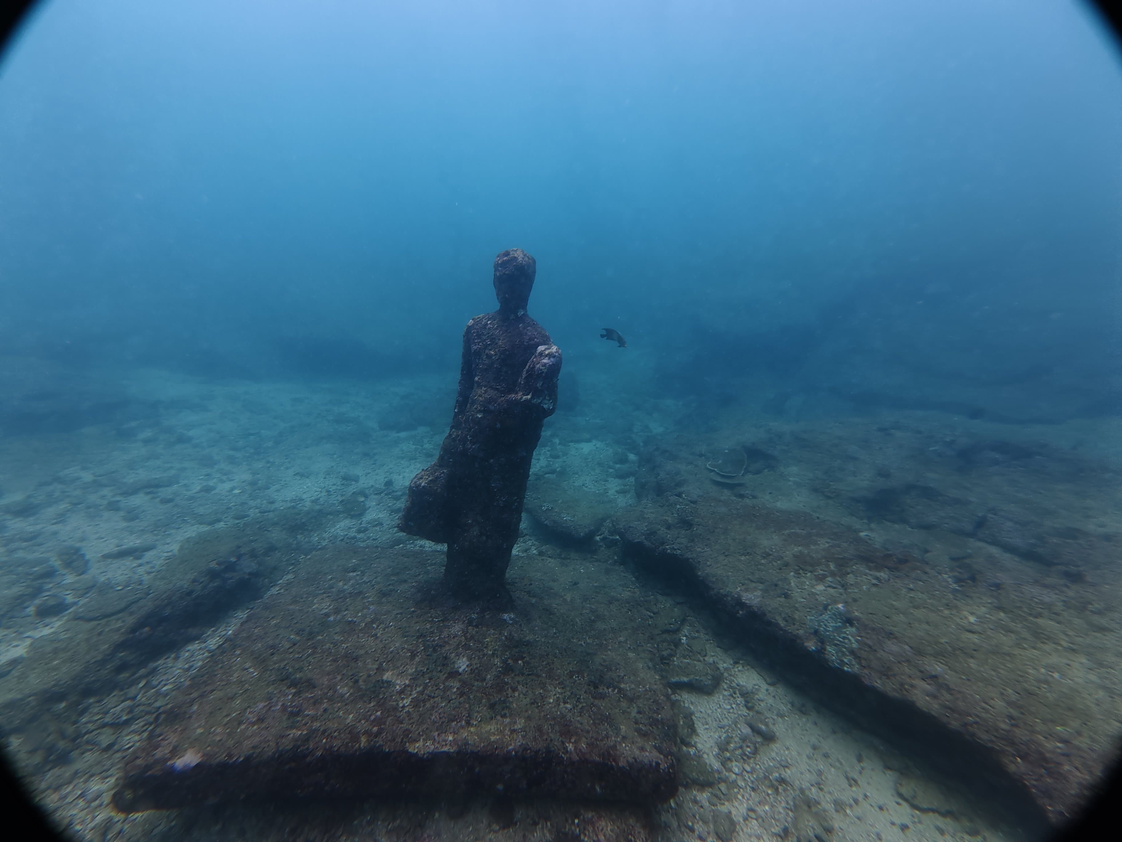 Underwater statue at a dive site in the clear blue water off Unawatuna